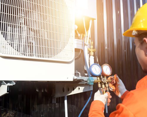 A professional air conditioner technician checking the refrigerant.