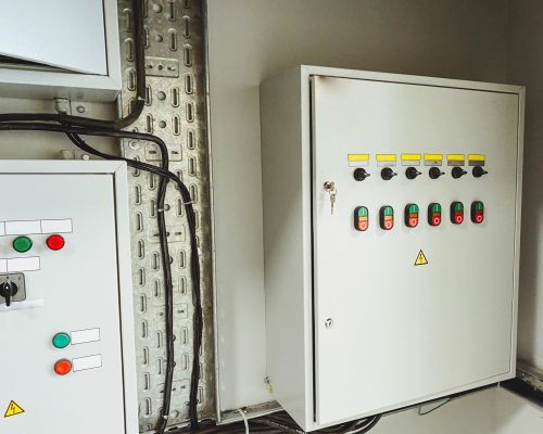 Electrical room of residential or commercial building. Multiple smart meters, main power breaker, meter stacks and cabinets. Perspective view