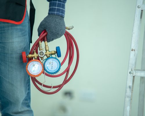 The technician is checking the air system,measuring equipment for filling air conditioners.